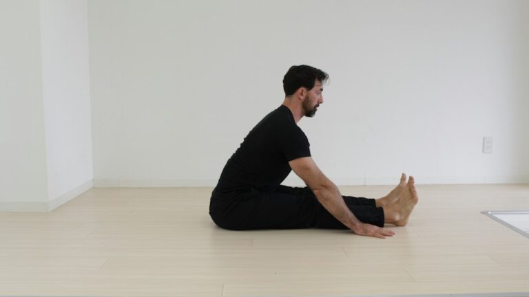 Person performing gentle seated mobility exercises on a chair in a bright home setting.